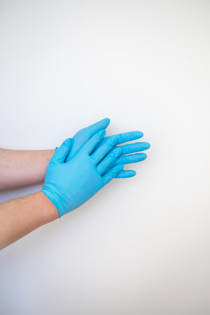 Hands in blue medical disposable gloves show a hand washing pattern, safe from germs and viruses. Place for an inscription, close-up.の写真素材