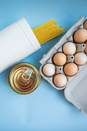 Food set. Coronavirus food delivery. Pasta, eggs, canned food. Contactless delivery of goods. The concept of quarantine and isolation during a pandemicの写真素材