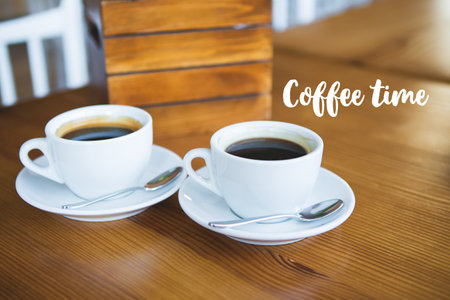 Two cups of coffee on a wooden table, a place for text. Inscription coffee time.の写真素材