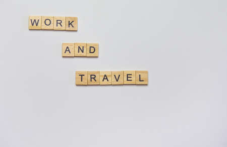 Wooden inscription from cubes - work and travel on a white background, top viewの写真素材
