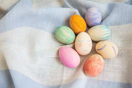 Painted multicolored Easter eggs, eggs painted with watercolors. A cute face in the middle of painted eggs. Easter cardの写真素材