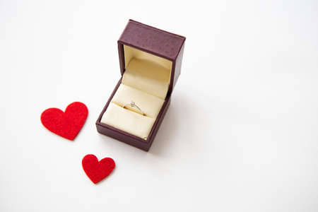 Beautiful red hearts on a white background together with a ring in a box. Marriage proposalsの写真素材