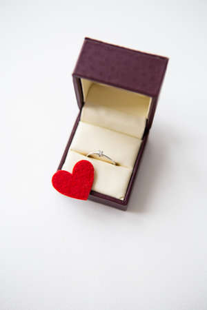 Beautiful red hearts on a white background together with a ring in a box. Hand and heart proposals, close-upの写真素材