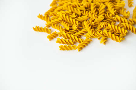 Fusilli pasta close-up on a white plate. Natural pasta made from hard wheat with the addition of pumpkinの写真素材