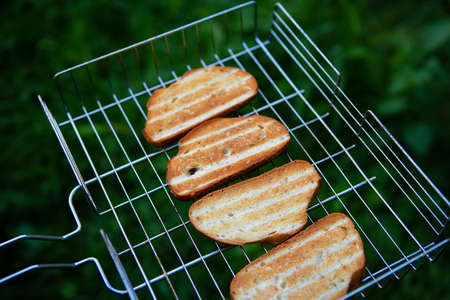 Grilled crispy toast on the wire rack. Outdoor recreation. Bonfire, grill, delicious. View from aboveの写真素材