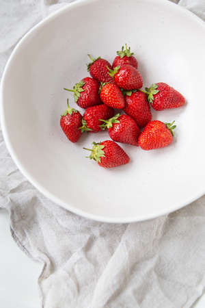 Juicy, tasty, ripe strawberries on a plate, top view. Vertical photo. Place for an inscriptionの写真素材