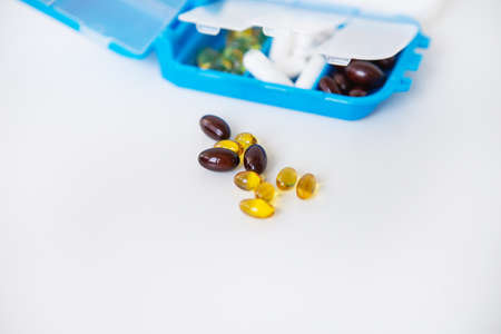 Pouring pills and capsules on a white background close-up. Top view with copy space. Medicine conceptの写真素材
