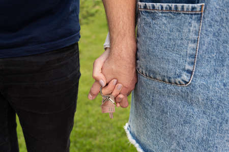 Happy young couple rejoices in buying an apartment, the couple holds in their hands the keys to their new home. Buying a homeの写真素材