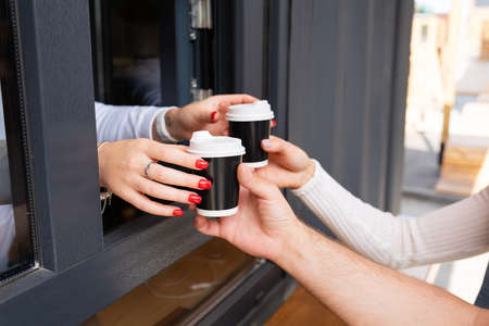 Couple takes takeaway coffee. Break and go outside. Outdoor dateの写真素材