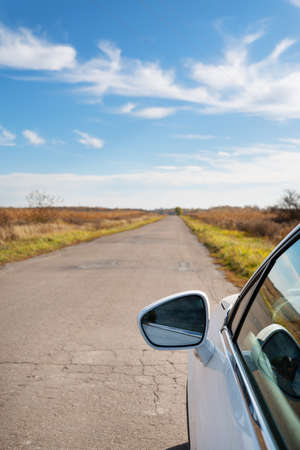 Bad old road, many holes in the street asphalt. Traveling by car, car problem, stopping, repairingの写真素材