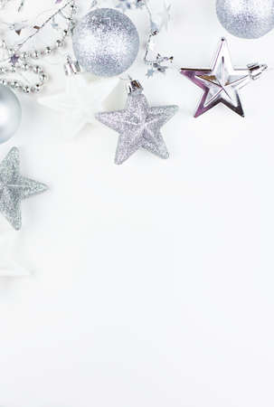 Festive mood, preparation for the holiday. New Year's festive decor in silvery colors - toys, star, round balls, place for an inscriptionの写真素材