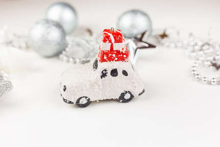 Beautiful festive decor in gray tones, a small car with gifts on the roof in the center of the frame. New Year's moodの写真素材