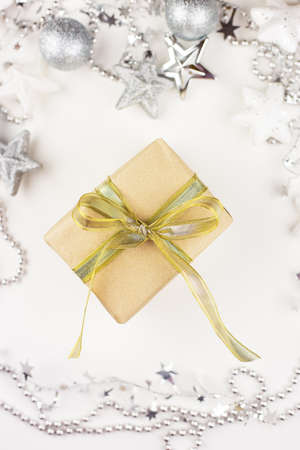 A golden gift box stands in the center of the frame, created from craft paper on a white background. View from above. Present timeの写真素材