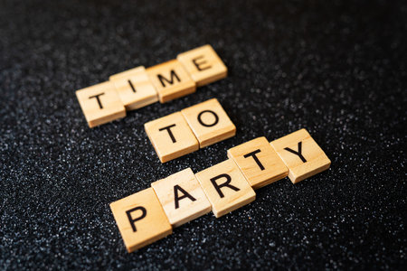 Party time wooden lettering on black shiny background. Fun and partying conceptの写真素材
