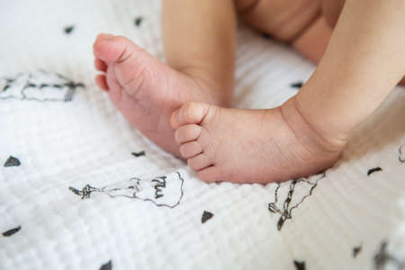Small feet of a newborn baby. The concept of motherhood, breastfeeding