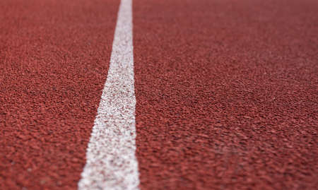 Red plastic covering on the playground, white stripe. Preparing for the competition. Place for an inscriptionの写真素材