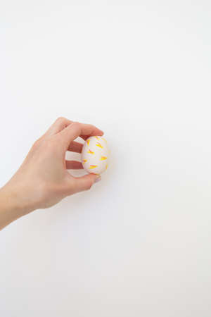 Girl holding Easter egg painted with watercolors in her hands, isolated on white backgroundの写真素材