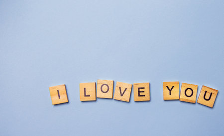 Inscription I love you in wooden letters on a blue background. Ready postcard, banner, place for an inscriptionの写真素材