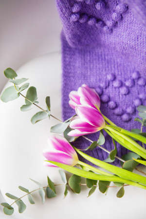 Spring beautiful bouquet of purple tulips with eucalyptus on a white chair along with a purple sweater. Spring mood, 8 March. Postcard for the holidayの写真素材