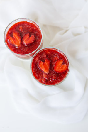 Strawberry and chia seed pudding in a cup for breakfast and strawberries in the shape of a heart. February 14, St. Valentine's Dayの写真素材