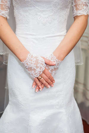Beautiful brides hands in white gloves closeupの写真素材