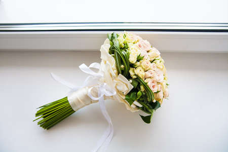 beautiful bridal bouquet of roses lying on the windowsillの写真素材