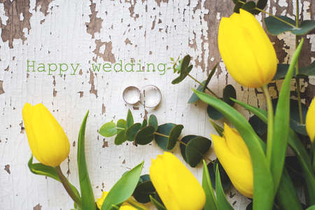 wedding rings with yellow tulips, inscription happy weddingの写真素材