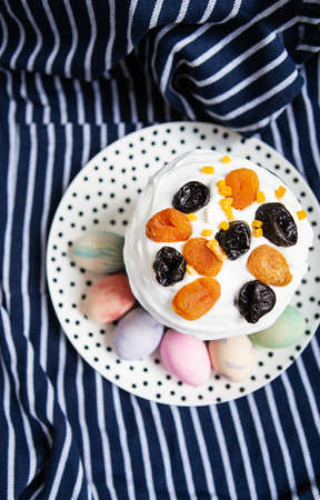 Easter eggs and Easter cake lie on a plate lying on a striped blue apron. Easter religious holiday conceptの写真素材