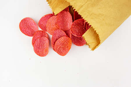 selective focus. Macro chips in a craft bag. Spices and salt on red spicy chips. Red chips with hot spicesの写真素材