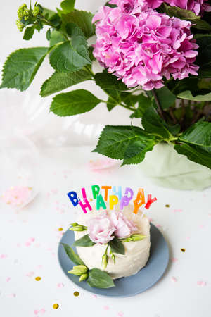Very beautiful bento cake, decorated with fresh eustoma flowers on the background of sweets and the inscription happy birthday, balloons, flowers. holiday conceptの写真素材
