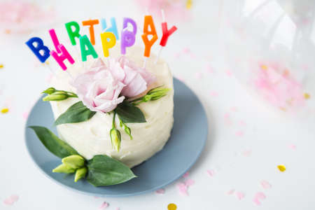 Very beautiful bright bento cake, decorated with fresh eustoma flowers against the background of sweets and the inscription happy birthday, balloons. The concept of holidays and smilesの写真素材