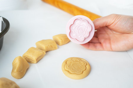 The process of making cookies with shapes in the form of flowers, a rolling pin and a tray, the concept of cooking, baking at homeの写真素材
