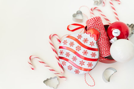 Christmas candies, along with cookie cutters, Christmas tree toys and red thread for gift wrapping, lie on a white table. Selective focus, noise. Christmas and New Year 2023-2024. Place for an inscriptionの写真素材