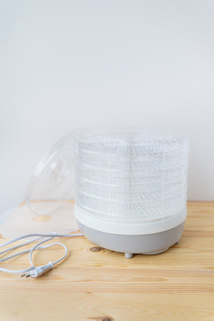 The process of homemade dried fruit or candied fruit in an electric dryer on the table. Fruits for storage and consumption in winterの写真素材
