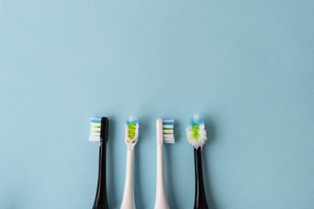 Modern electric toothbrush on a blue background, it's time to change the brush - old and new brush attachment. Hygiene concept for daily oral careの写真素材
