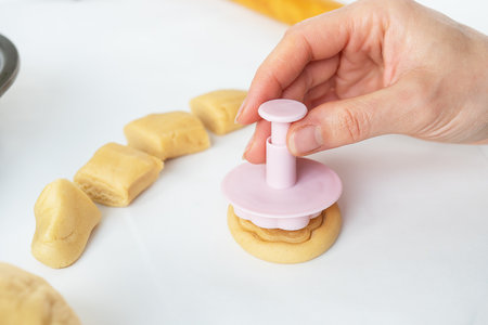 The process of making cookies with shapes in the form of flowers, a rolling pin and a tray, the concept of cooking, baking at homeの写真素材