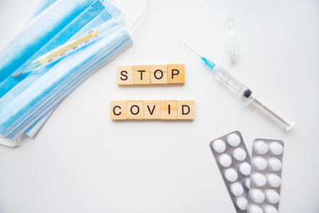 Stop coronavirus inscription. Preparation for vaccination against covid-19. Syringe, vaccine, pills, medical maskの写真素材