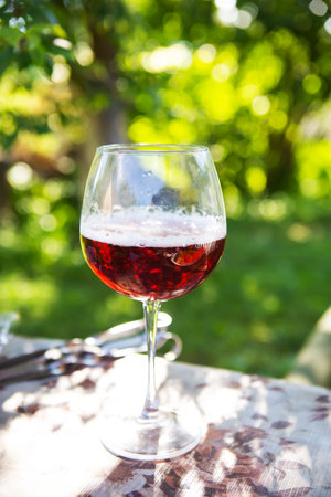A glass of dark beer in a glass, standing on a table, outdoor recreation. Summer picnicの写真素材