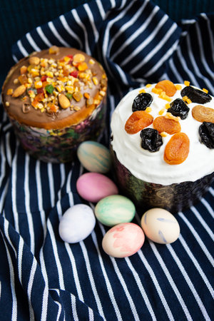 Easter eggs and Easter cakes lie on a striped blue apron. Easter religious holiday conceptの写真素材