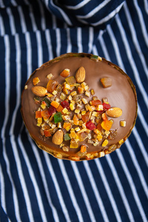 An Easter cake decorated with candied fruits stands on a striped blue apron. Easter religious holiday conceptの写真素材