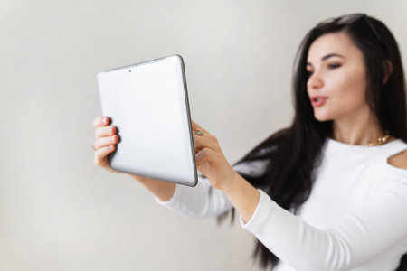 Portrait of a happy young business woman using a tablet working outside the office. Modern technologies and businessの写真素材