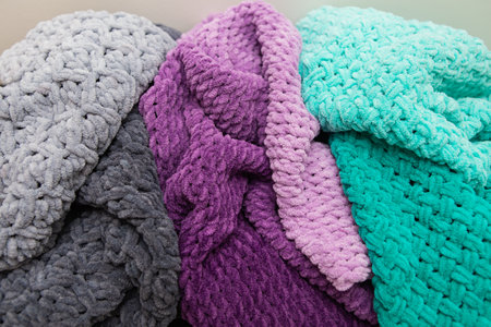 Beautiful plush multi-colored blankets of different colors lie together. close-upの写真素材
