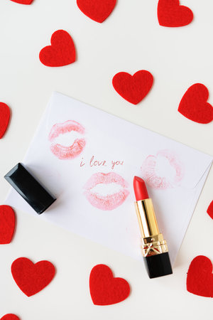 The inscription I love you on a white envelope with a print of lips with red lipstick on a background of small red hearts. The concept of St. Valentine's Dayの写真素材