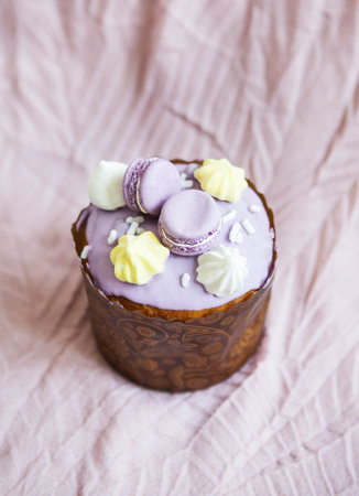 A traditional paska decorated with white Swiss chocolate and meringue stands on a lavender tablecloth. easter holidayの写真素材