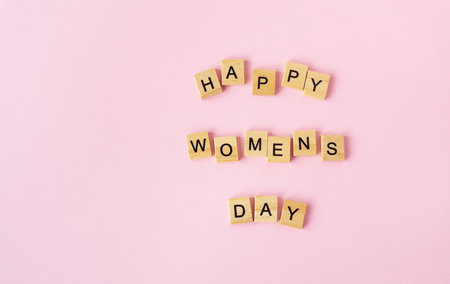 March 8, postcard. Text sign from wooden letters Happy Women's Day on a pink background. Stylish flat lay greeting cardの写真素材
