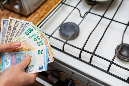 Payment of utility bills, calculations on a calculator. Euro and dollar bills lie near a burning gas burner. The concept of increasing the cost of natural gas supply and payment. energy crisis, top viewの写真素材