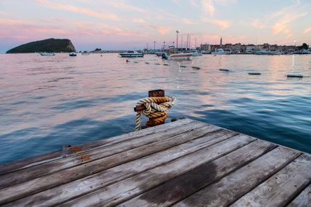 A very beautiful sunset on the pier, a beautiful sky on the sea, against the backdrop of a pier and a pier with yachts against the backdrop of a resort townの写真素材