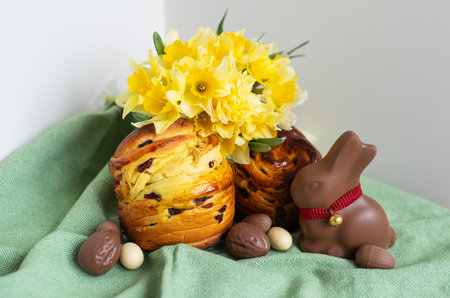 Homemade Easter traditional pastries lie on a green napkin along with daffodil flowers, rabbit, chocolate eggs. Easter baking and decorationの写真素材