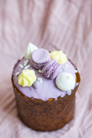 A traditional paska decorated with white Swiss chocolate and meringue stands on a lavender tablecloth. easter holidayの写真素材