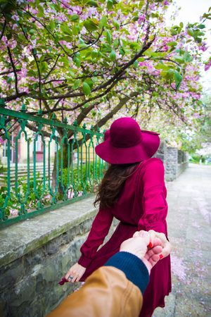 rear view - Woman holding the hand of manの写真素材